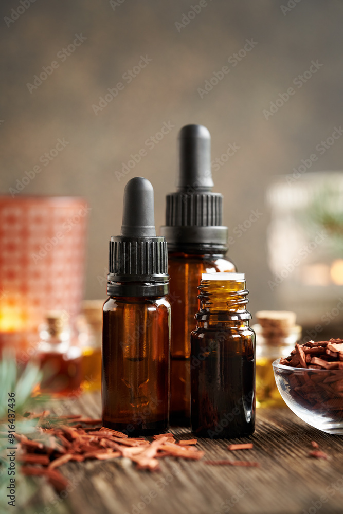 Bottles of aromatherapy essential oil with red sandalwood chips on a table Bottles of aromatherapy essential oil with red sandalwood chips on a table