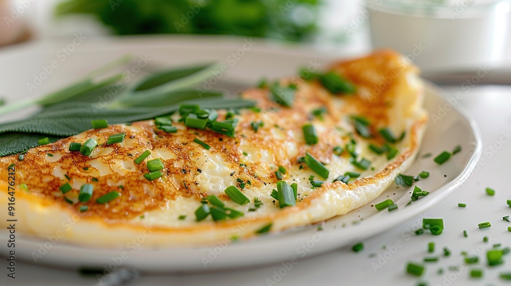 A white plate, topped with a cheesy omelette, garnished with fresh green leaves A white plate, topped with a cheesy omelette, garnished with fresh green leaves