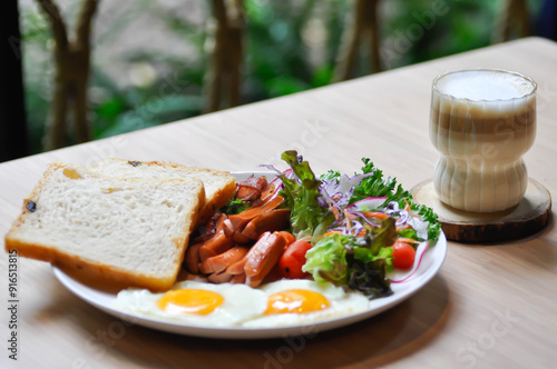 breakfast or bread with sunny side up egg, sausage and vegetable and hot coffee photo