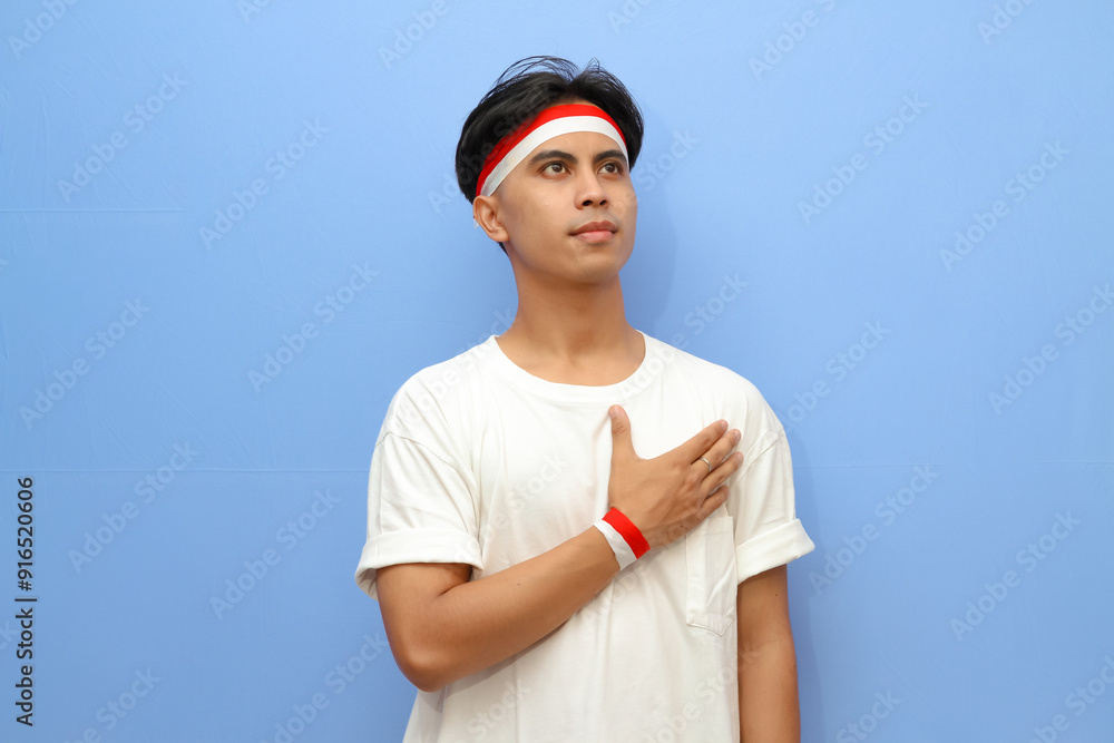 Indonesian man in white shirt and Indonesian flag posing proudly and saluting, Indonesian independence day concept Indonesian man in white shirt and Indonesian flag posing proudly and saluting, Indonesian independence day concept