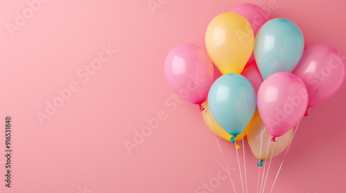 A group of colorful balloons tied together, floating against a pink background.