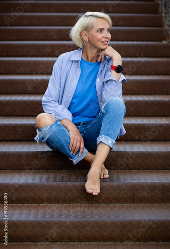 Portrait of attractive woman sitting on a staircase of an office building