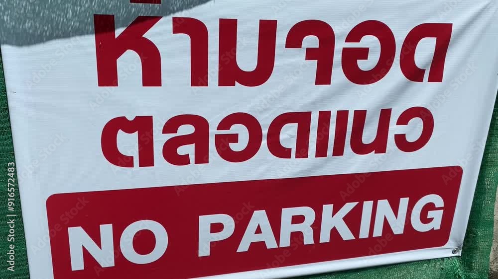 NO PARKING sign on public wall outdoor sunshine on sign, Thailand. Thai language on sign means No parking here NO PARKING sign on public wall outdoor sunshine on sign, Thailand. Thai language on sign means No parking here