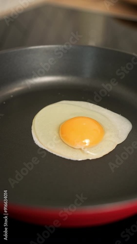 hands breaking an egg into a frying pan photo