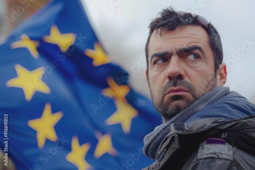 Immigration fuels rise in populist movements across EU.  Syrian man focus eu flag represents identity and migration tension. The juxtaposition of struggle and solidarity man's gaze and flag. photo