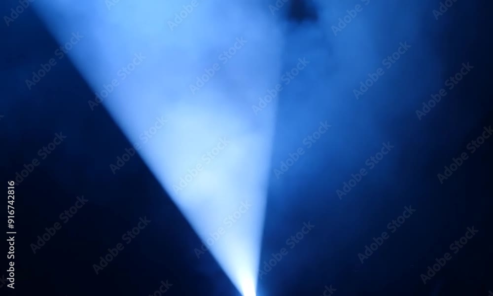 Spotlight Beam Through Smoke: A single, powerful spotlight cuts through a curtain of swirling blue smoke, creating a dramatic and ethereal effect. The soft, diffused light casts a mesmerizing glow on Spotlight Beam Through Smoke: A single, powerful spotlight cuts through a curtain of swirling blue smoke, creating a dramatic and ethereal effect. The soft, diffused light casts a mesmerizing glow on