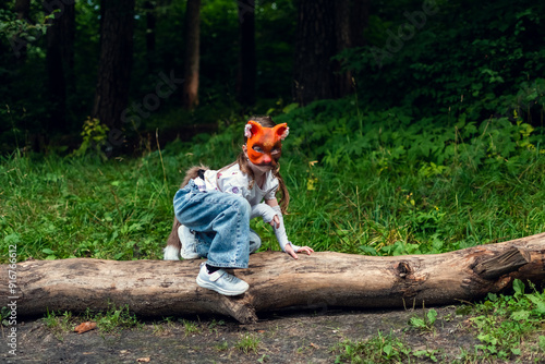 A girl with cat mask, tail and gloves doing Quadrobics in the forest.