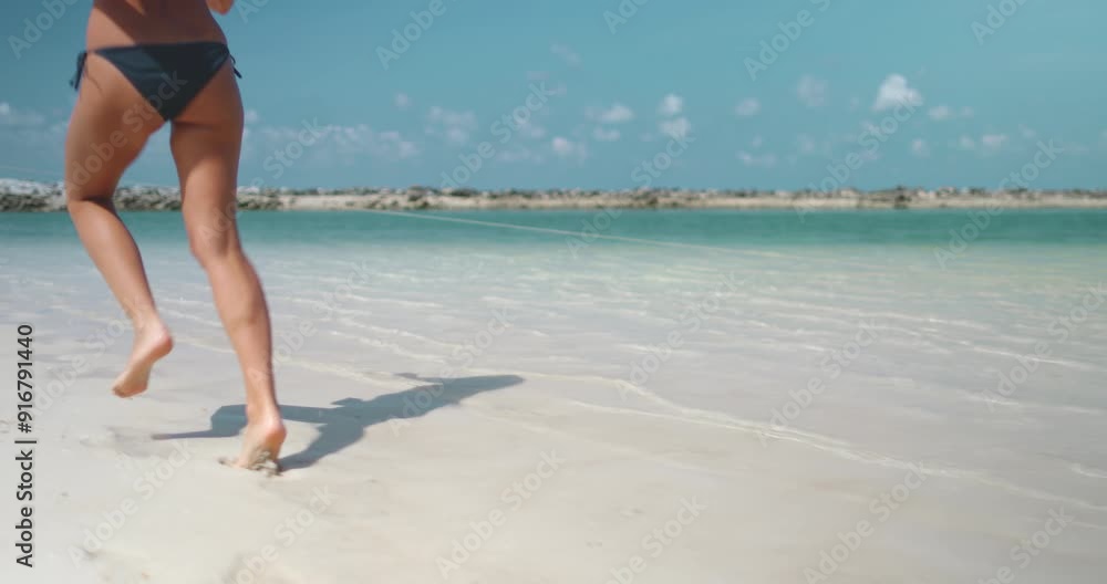 Young woman is running towards the ocean on a pristine beach in thailand, enjoying the warm weather and crystal-clear water Young woman is running towards the ocean on a pristine beach in thailand, enjoying the warm weather and crystal-clear water