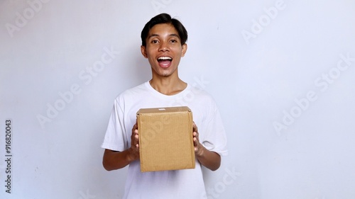 Asian young man happy wearing white shirt gesture holding package box