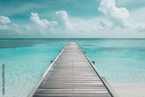 Fototapeta Naklejka Na Ścianę i Meble -  A wooden beach pier leading into turquoise water of the maldives. Maldives on a tropical beach scene