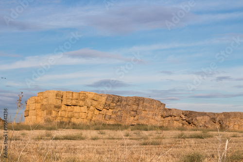 Rural scene featuring large stacks of straw and hay in the middle of a field, capturing a typical Castilian landscape in Spain