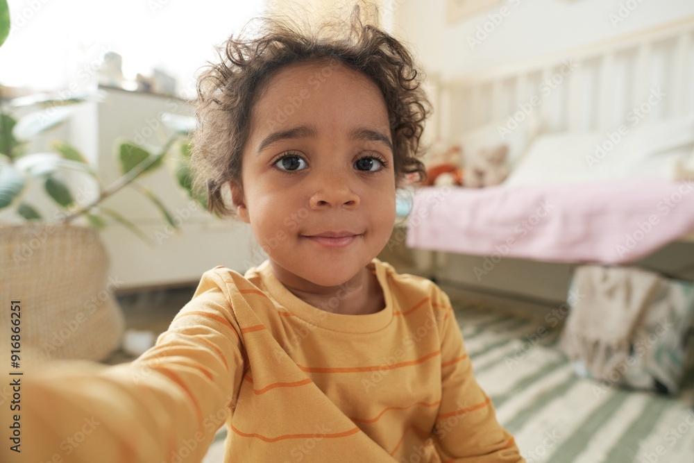 Portrait of smiling child in cozy bedroom with pastel decor, bed in background, potted plant partially visible in corner, capturing warm and inviting atmosphere Portrait of smiling child in cozy bedroom with pastel decor, bed in background, potted plant partially visible in corner, capturing warm and inviting atmosphere
