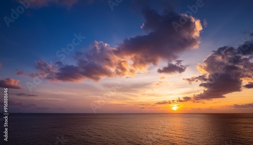 dusk sky over sea sunset sky clouds in the evening with golden orange sunlight and dark blue hour on twilight after sun down horizon sea sky background in summer season #916888646