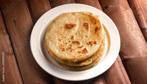 moli poratha with a perfectly cooked golden crust resting on a white ceramic plate with a natural wood backdrop photo