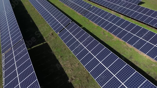 The photovoltaic power station gleams with solar panels capturing the sun's energy, generating clean electricity under the brilliant daylight. Renewable energy and Carbon footprint reduction concept.  photo