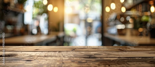 Focused on an empty brown wooden table, with a blurry Coffee shop background creating a bokeh effect, ideal for product display montage with copy space image.