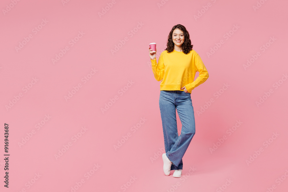 Full body young happy woman wear yellow sweatshirt casual clothes hold takeaway delivery craft paper cup coffee to go isolated on plain pastel light pink background studio portrait. Lifestyle concept. Full body young happy woman wear yellow sweatshirt casual clothes hold takeaway delivery craft paper cup coffee to go isolated on plain pastel light pink background studio portrait. Lifestyle concept.
