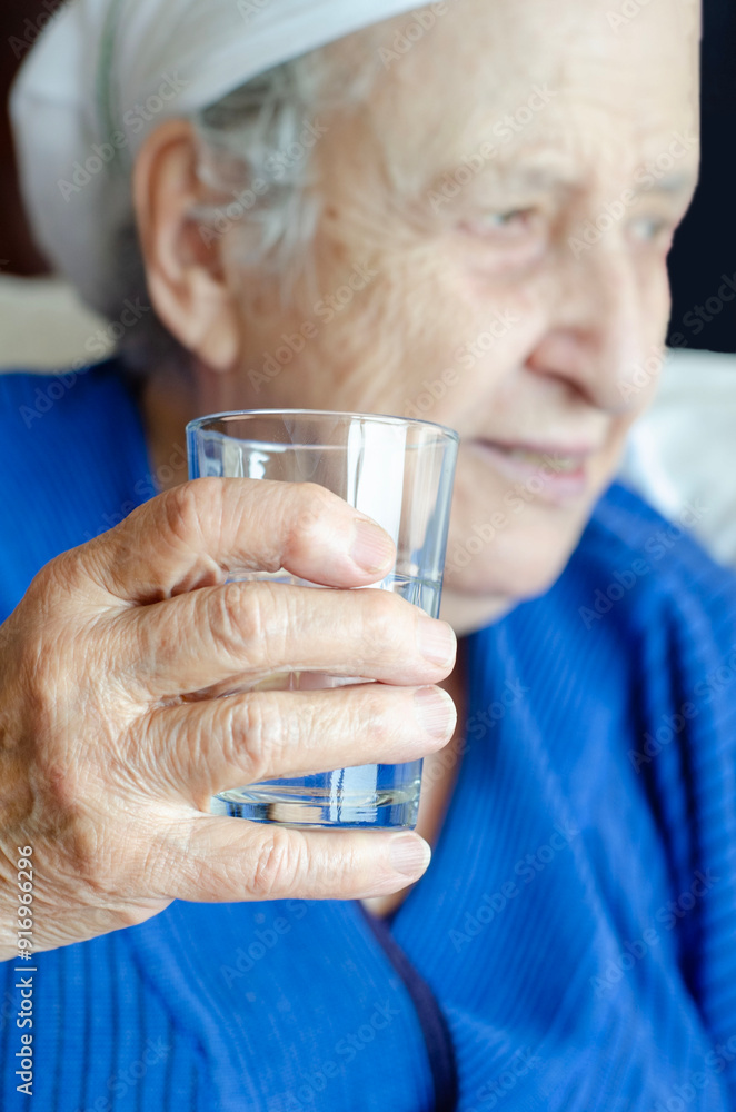 closeup wrinkled hand of old senior woman holding water glass. closeup wrinkled hand of old senior woman holding water glass.