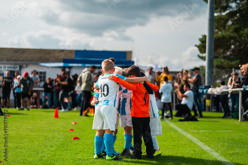 Group of Young Boy Football Players Coming Together to Team Up and Win the Game