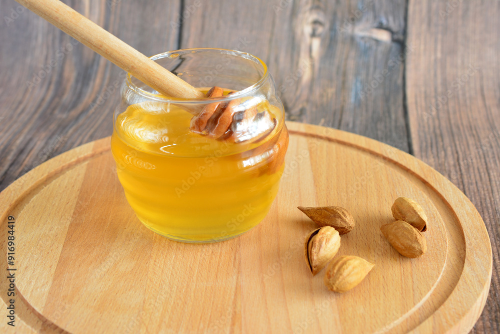 a jar of honey with a wooden stick next to it on the cutting board a jar of honey with a wooden stick next to it on the cutting board