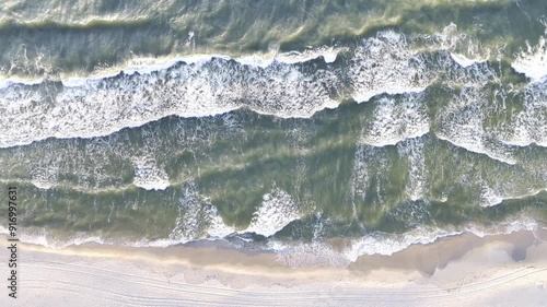 Morze Bałtyckie, zachodząca słońce i pusta piaszczysta plaża. 