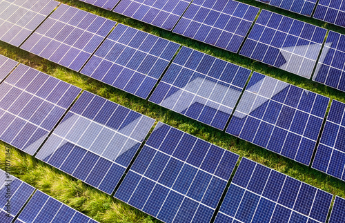 Upward line graph with arrow superimposed on rows of solar panel. Representing growth in production, efficiency and usage. Increasing demand of renewable energy usage. photo