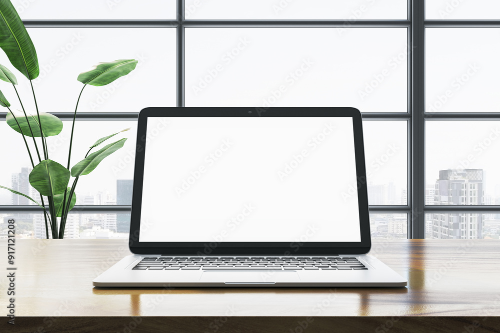 Fototapeta premium Modern laptop with blank screen on wooden desk in office with city view. 3D Rendering