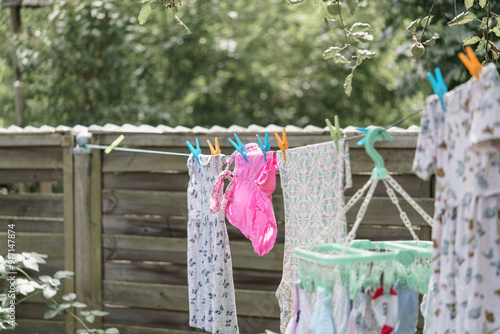 Принти на полотні Clean baby clothes are hung out to dry outside after washing.