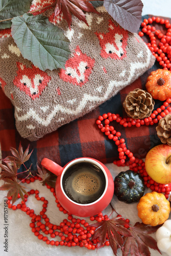 Autumn still life with red mug and warm brown knitted sweater. Cloe up photo of colorful autumn composition. 