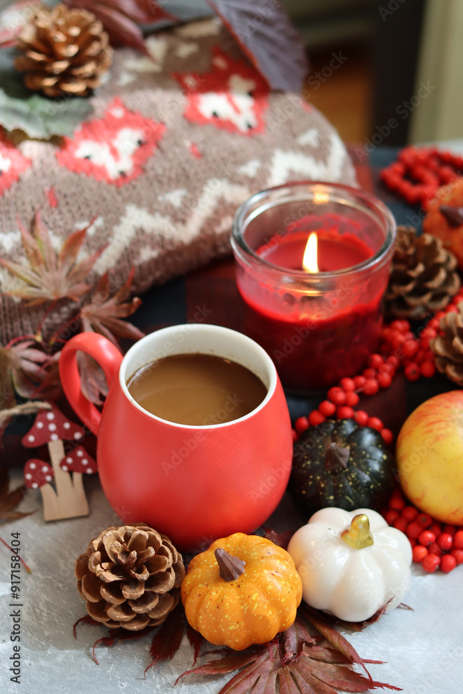 Autumn composition with cup of coffee, autumn leaves, red berries, pumpkins and knitted sweater Autumn composition with cup of coffee, autumn leaves, red berries, pumpkins and knitted sweater