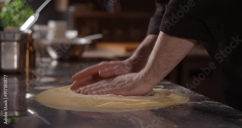Pizza chef rolls out the pizza dough in restaurant restaurant