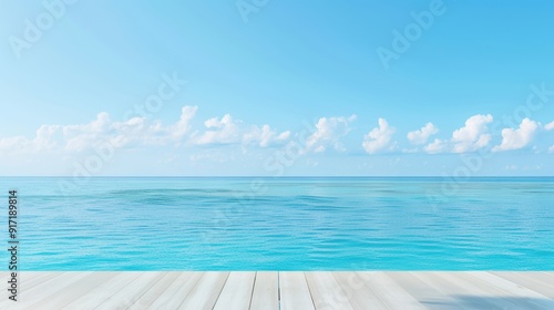 Serene ocean view with clear blue sky and fluffy clouds, seen from a wooden deck. Perfect for summer and vacation themes.