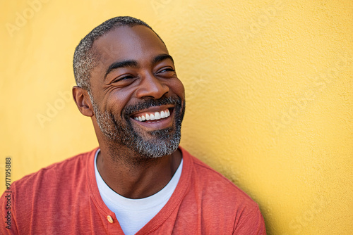 Sunlit Headshot of a Black Man in Red and White, Laughing Heartily with a Clean Focus and Professional Color Grading, Against a Yellow Wall