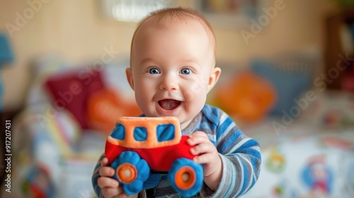 A smiling baby boy with blue eyes holds a toy car in his hand.