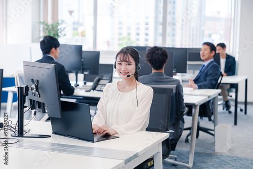 ヘッドセットをつけて話す若いビジネスウーマン