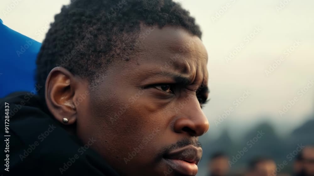 A determined protestor carries a heavy flag on their shoulder their steely gaze fixed on the front lines. A determined protestor carries a heavy flag on their shoulder their steely gaze fixed on the front lines.