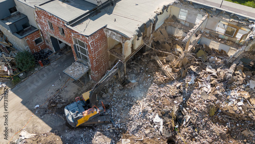 Фотография Drone photography of machinery dismantling a house and removing ruble during sunny summer day