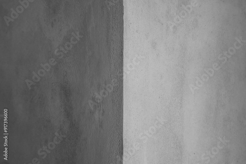Grey concrete wall corner background. Light and dark sides. Shadow on grey background. Industrial backdrop for design. Close-up, horizontal photo, selective focus.