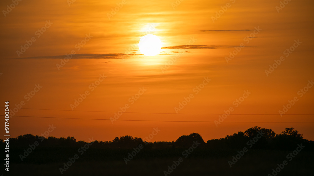 A breathtaking golden sunset over a serene rural landscape, perfect for illustrating summer evenings or environmental awareness themes A breathtaking golden sunset over a serene rural landscape, perfect for illustrating summer evenings or environmental awareness themes