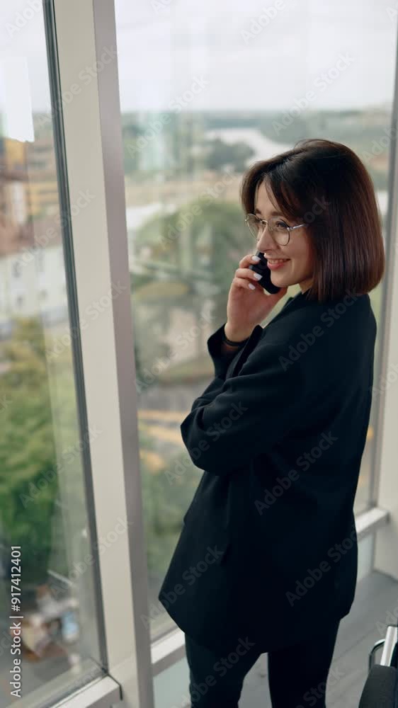 Laidback young lady speaking on the phone. Portrait of a modern businesswoman in office. Top view. Vertical video. Laidback young lady speaking on the phone. Portrait of a modern businesswoman in office. Top view. Vertical video.