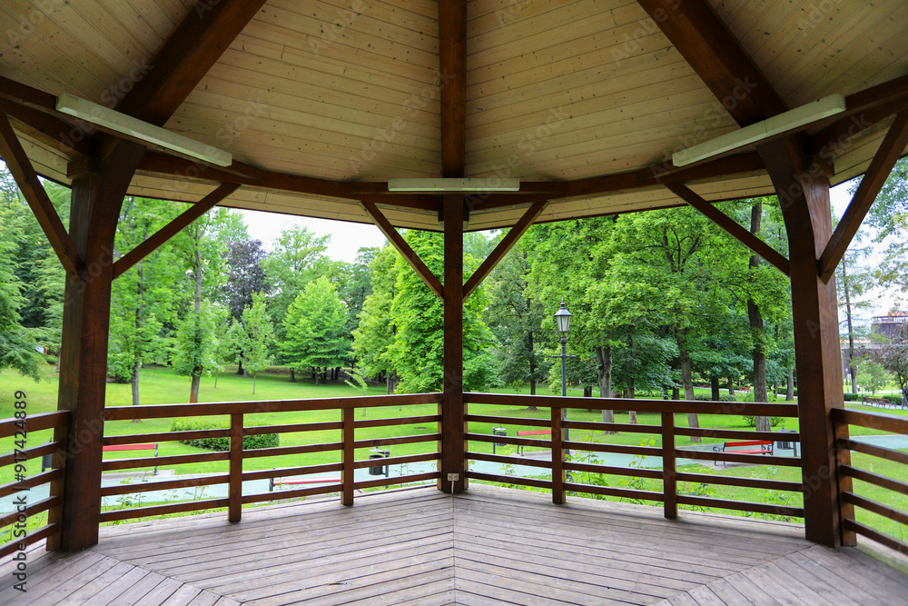 WIELICZKA, POLAND - 12 JULY 2022: Wooden gazebo in beautiful city park by the Salt Mine, Wieliczka, Poland. WIELICZKA, POLAND - 12 JULY 2022: Wooden gazebo in beautiful city park by the Salt Mine, Wieliczka, Poland.