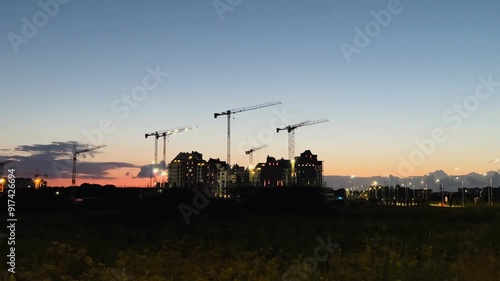 Twilight Construction: Urban Skyline with Cranes at Sunset