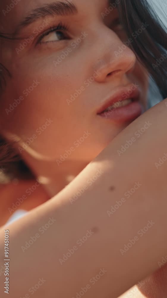 Close-up slow motion beauty portrait of an attractive young woman. She has brown eyes and brown hair blowing in the wind. Close-up slow motion beauty portrait of an attractive young woman. She has brown eyes and brown hair blowing in the wind.