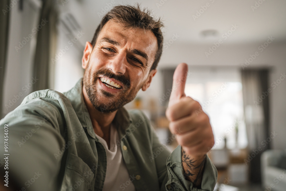 self portrait of adult excited man stand and thumb up gesture at home self portrait of adult excited man stand and thumb up gesture at home