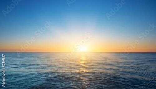 sunrise over calm ocean with clear blue sky