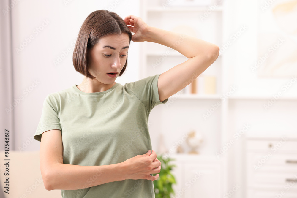 Emotional woman in t-shirt before using deodorant at home Emotional woman in t-shirt before using deodorant at home