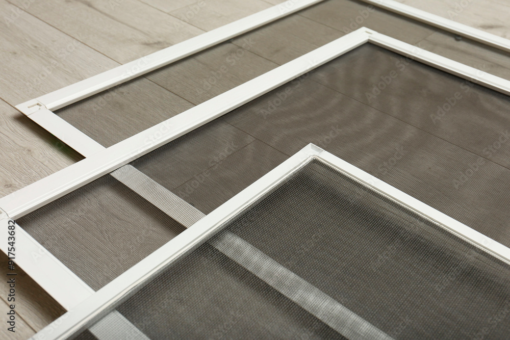 Obraz premium Set of window screens on wooden floor, closeup