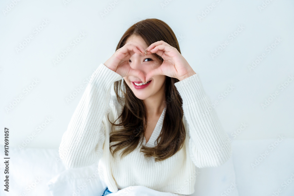 Front view of cute young Asian woman smiling and looking at camera with hands showing heart shape. Facial expressions and positive emotions, healthy life, love and charity Front view of cute young Asian woman smiling and looking at camera with hands showing heart shape. Facial expressions and positive emotions, healthy life, love and charity