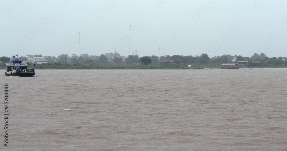 Front view of a ferry carrying cars and passengers on the Mekong River during a heavy rainfall