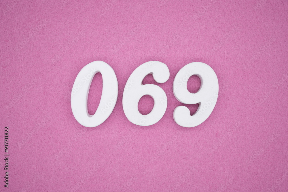 The numbers are made of white painted wood. Laying on the floor was pink paper. The numbers are made of white painted wood. Laying on the floor was pink paper.